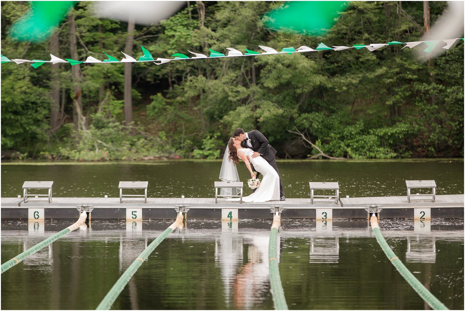 groom dipping his bride on the dock