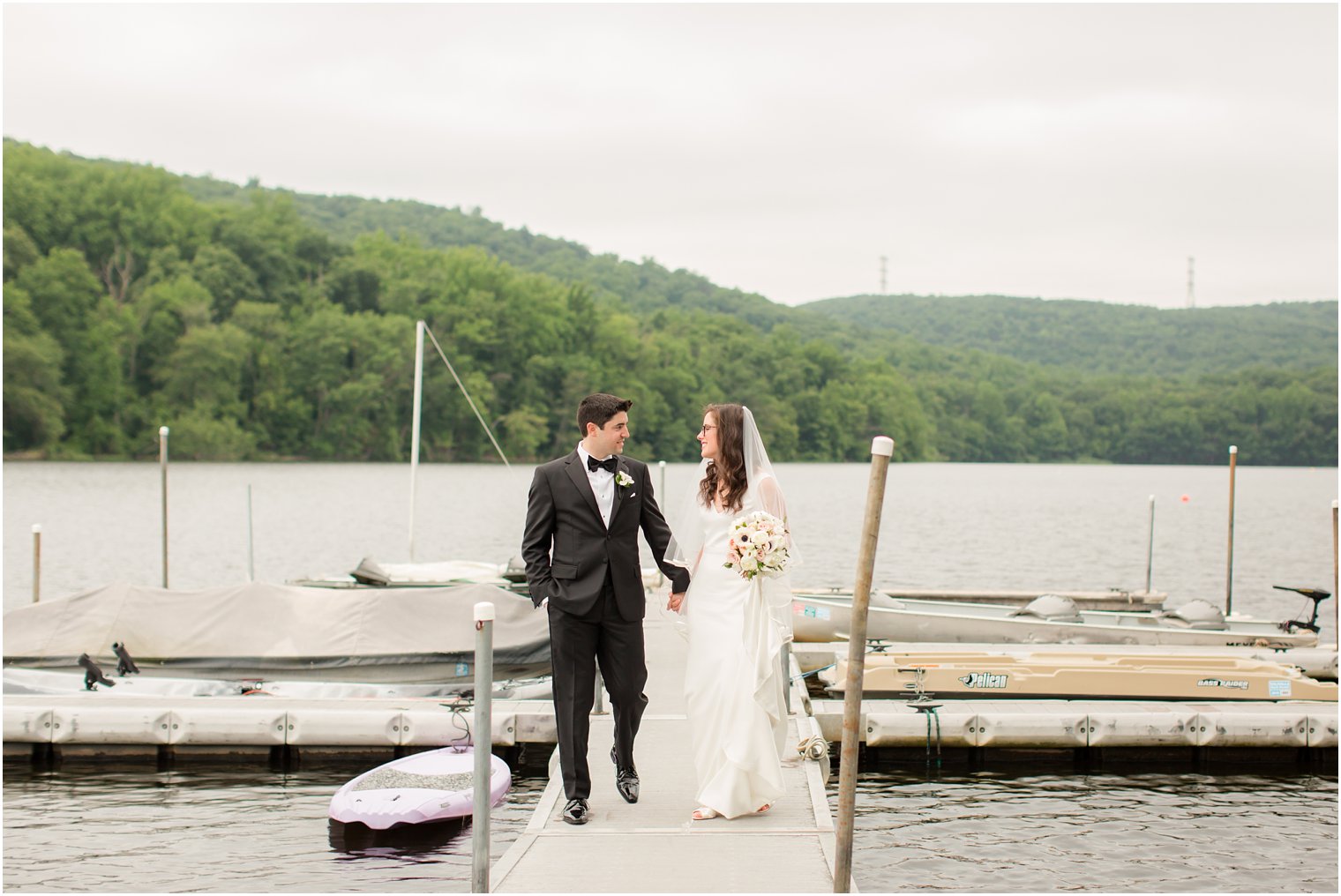 bride and groom walking on a dock
