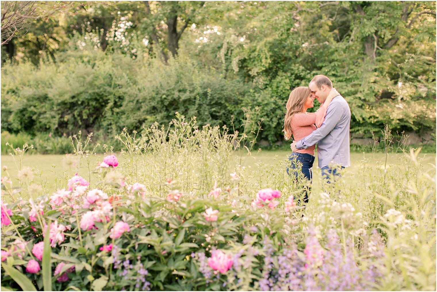 engaged couple kissing in a garden