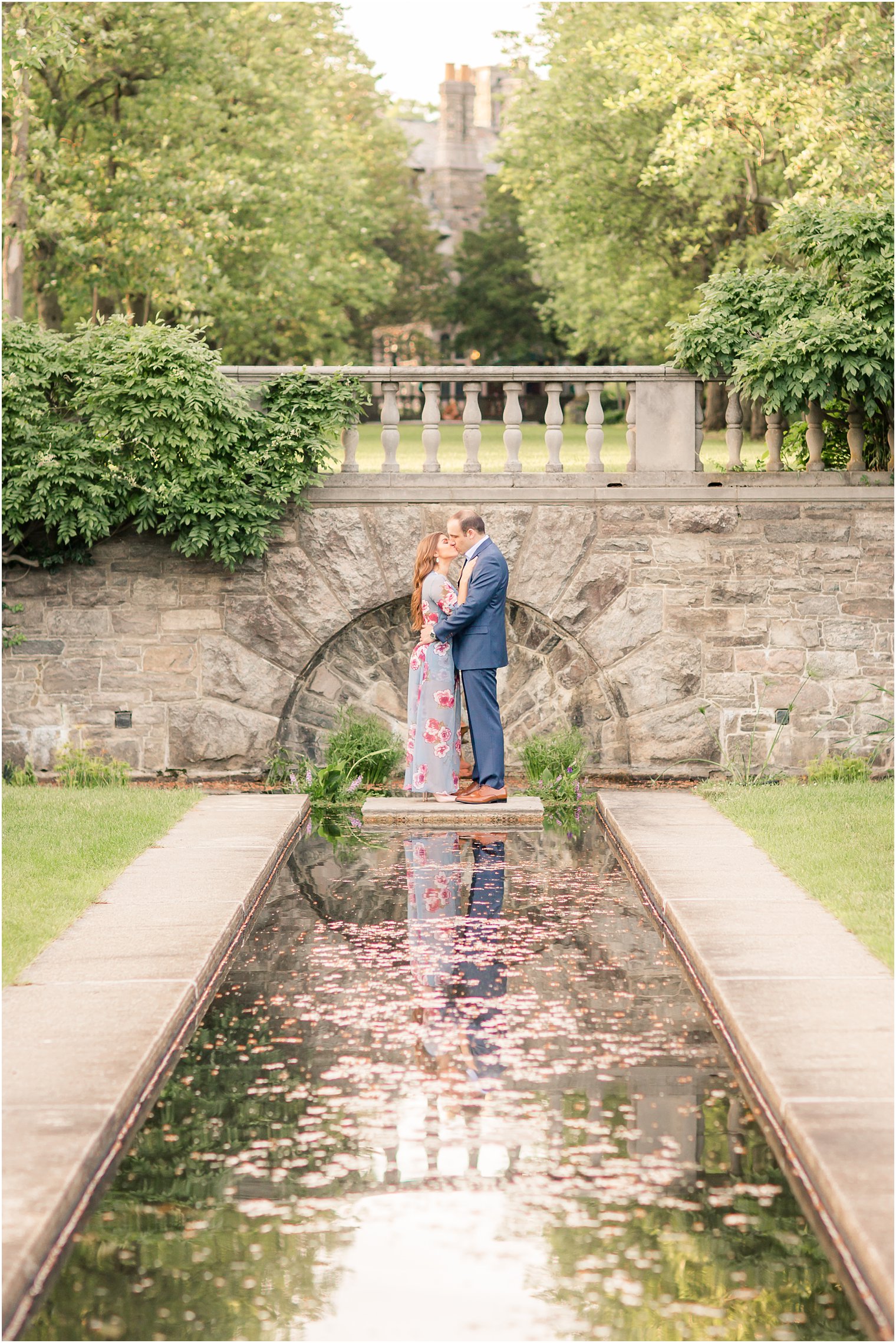 couple kissing near a reflective pond