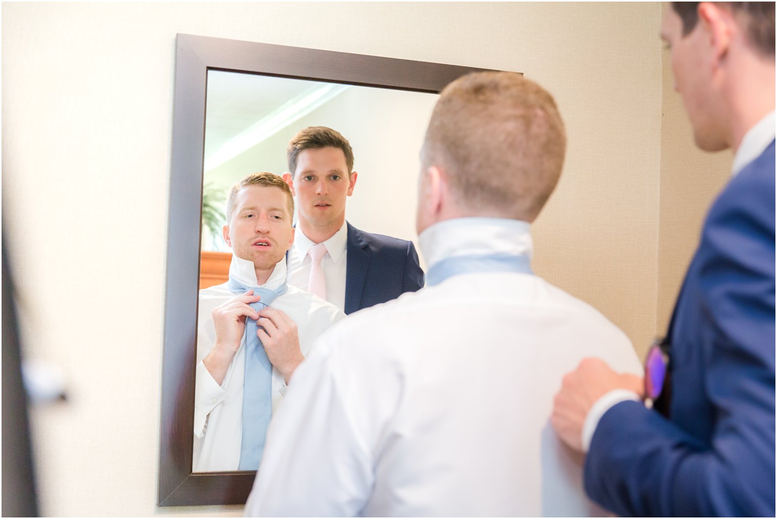 groom and best man looking in mirror