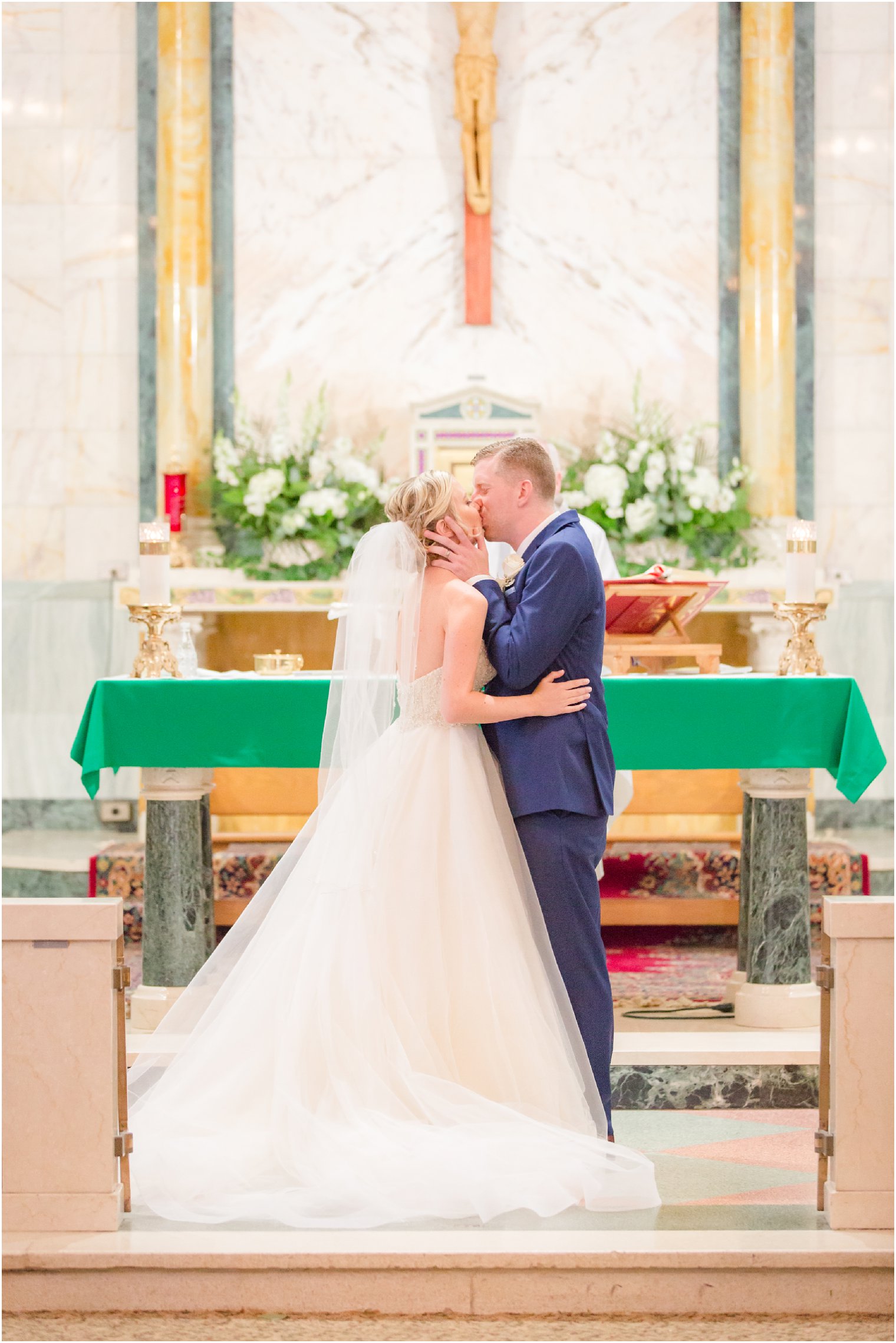 bride and groom's first kiss during Catholic wedding ceremony at St. Mark's in Sea Girt