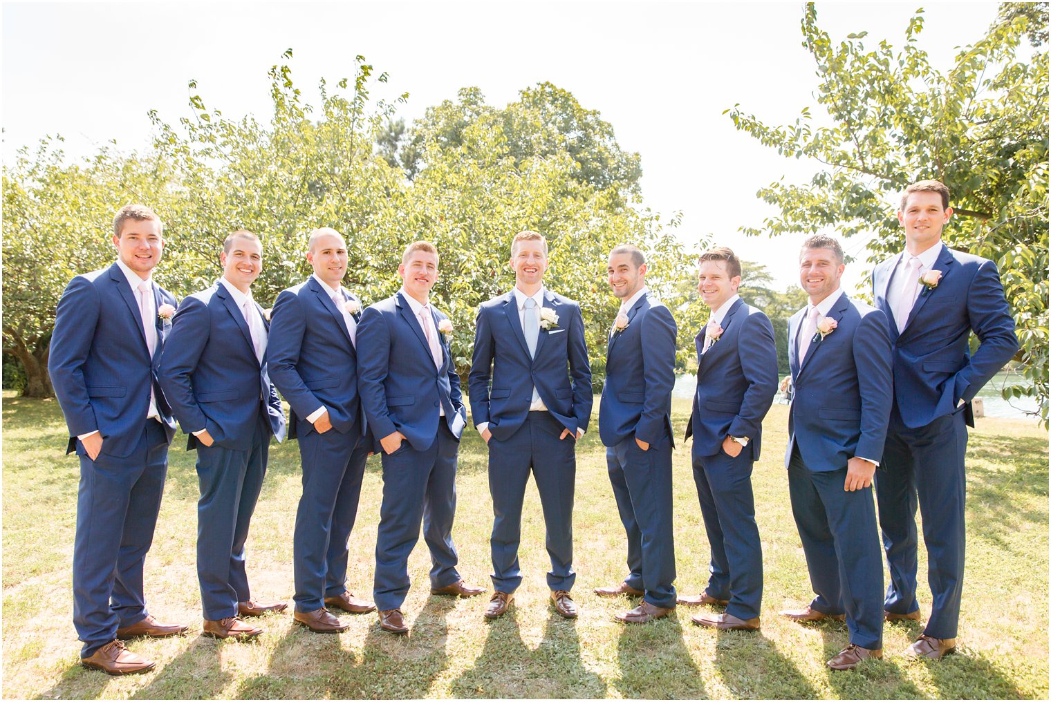 groomsmen wearing blue suits and pink ties