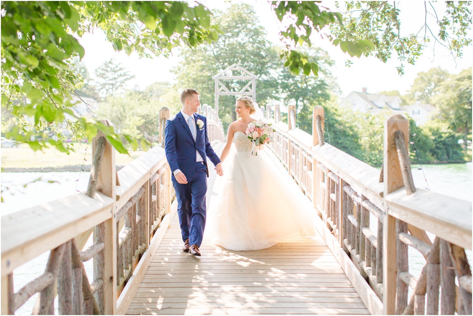 candid photo of bride and groom walking on bridge