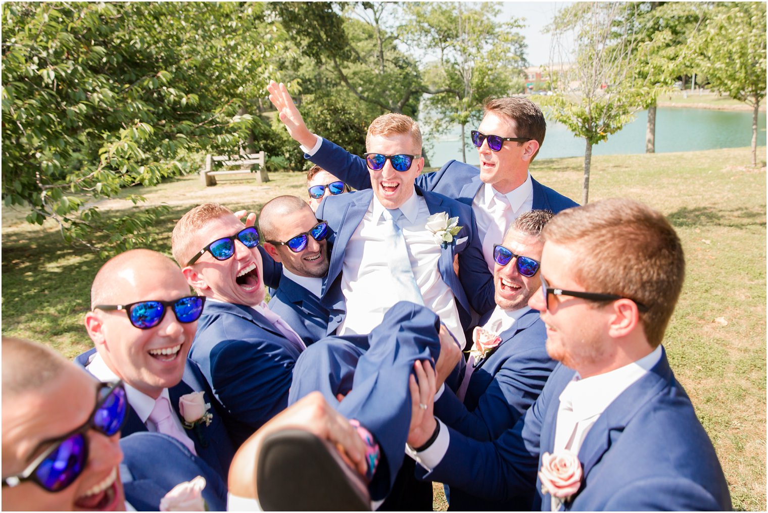 fun photo of groomsmen lifting groom in the air