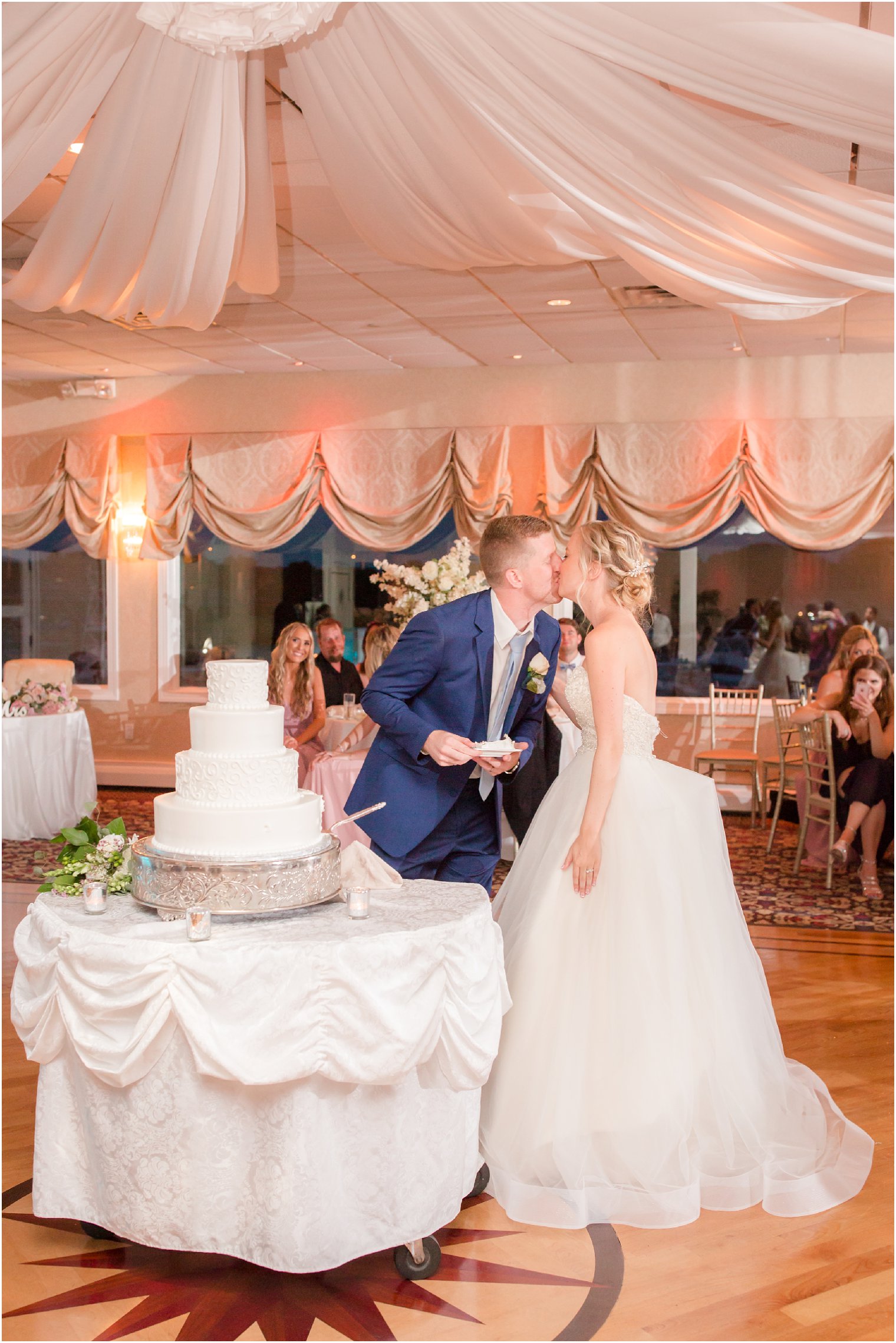 bride and groom sharing a kiss after cutting their cake 