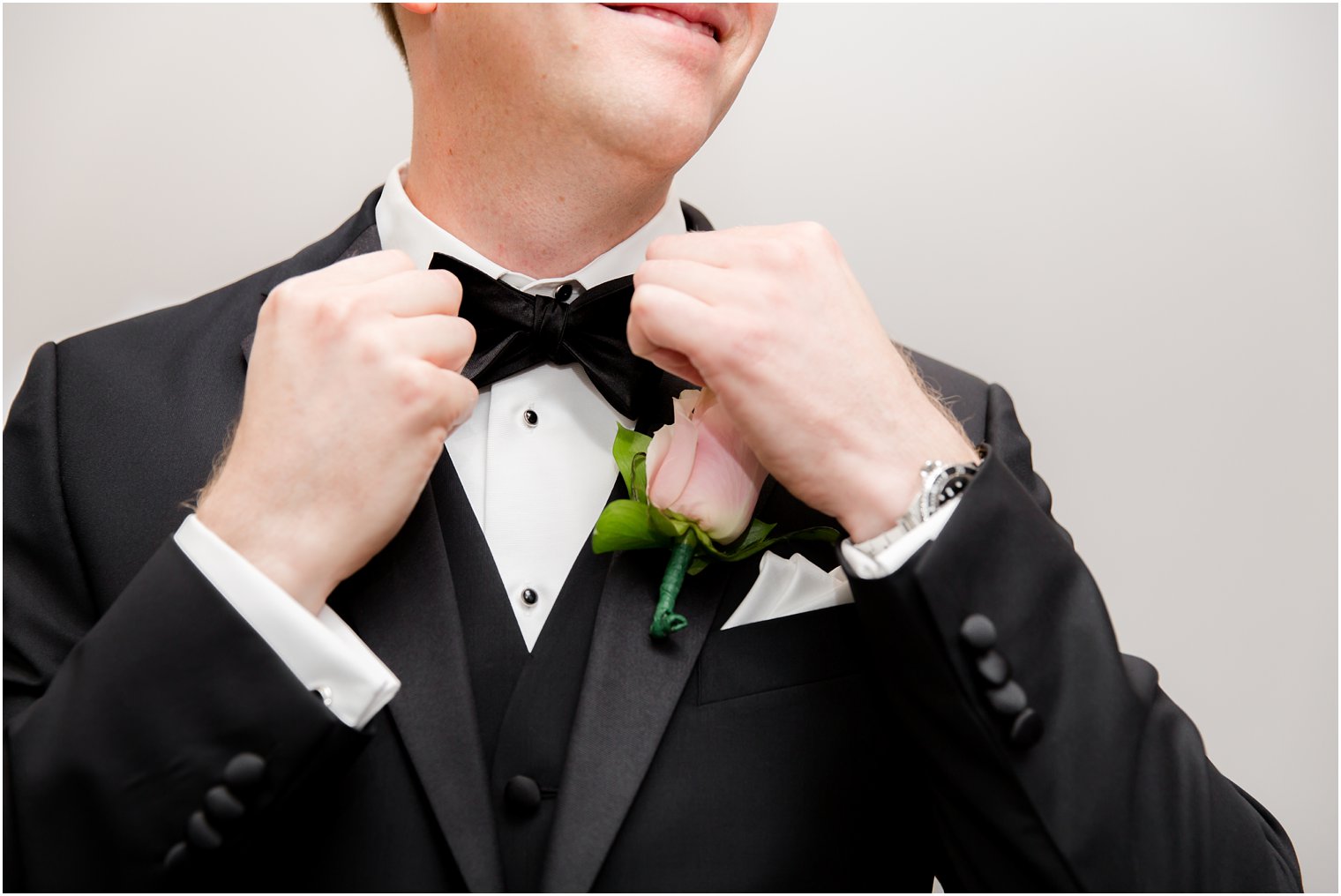 groom putting on bow tie