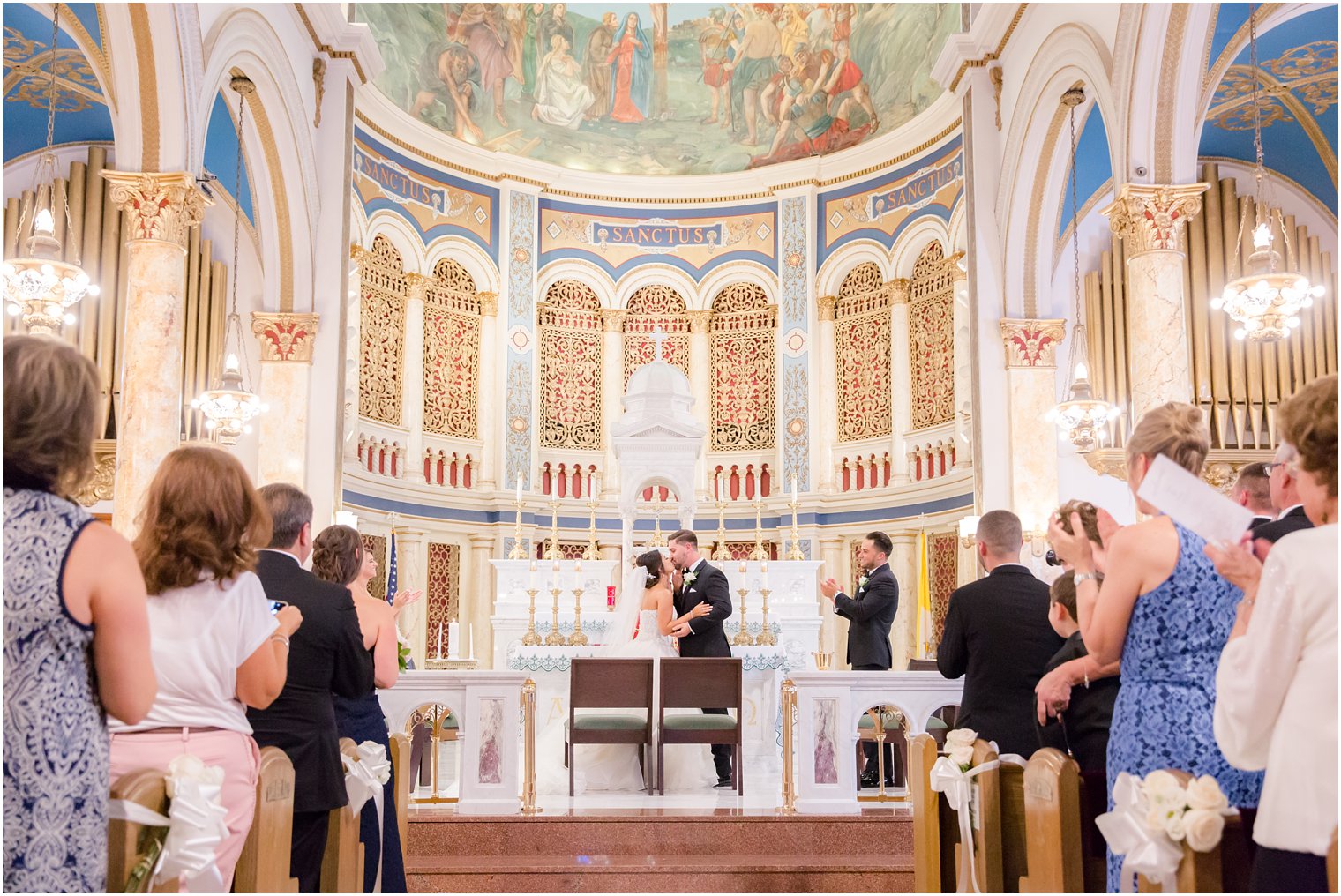 Bride and groom kissing at altar at St. Finbar Catholic Church