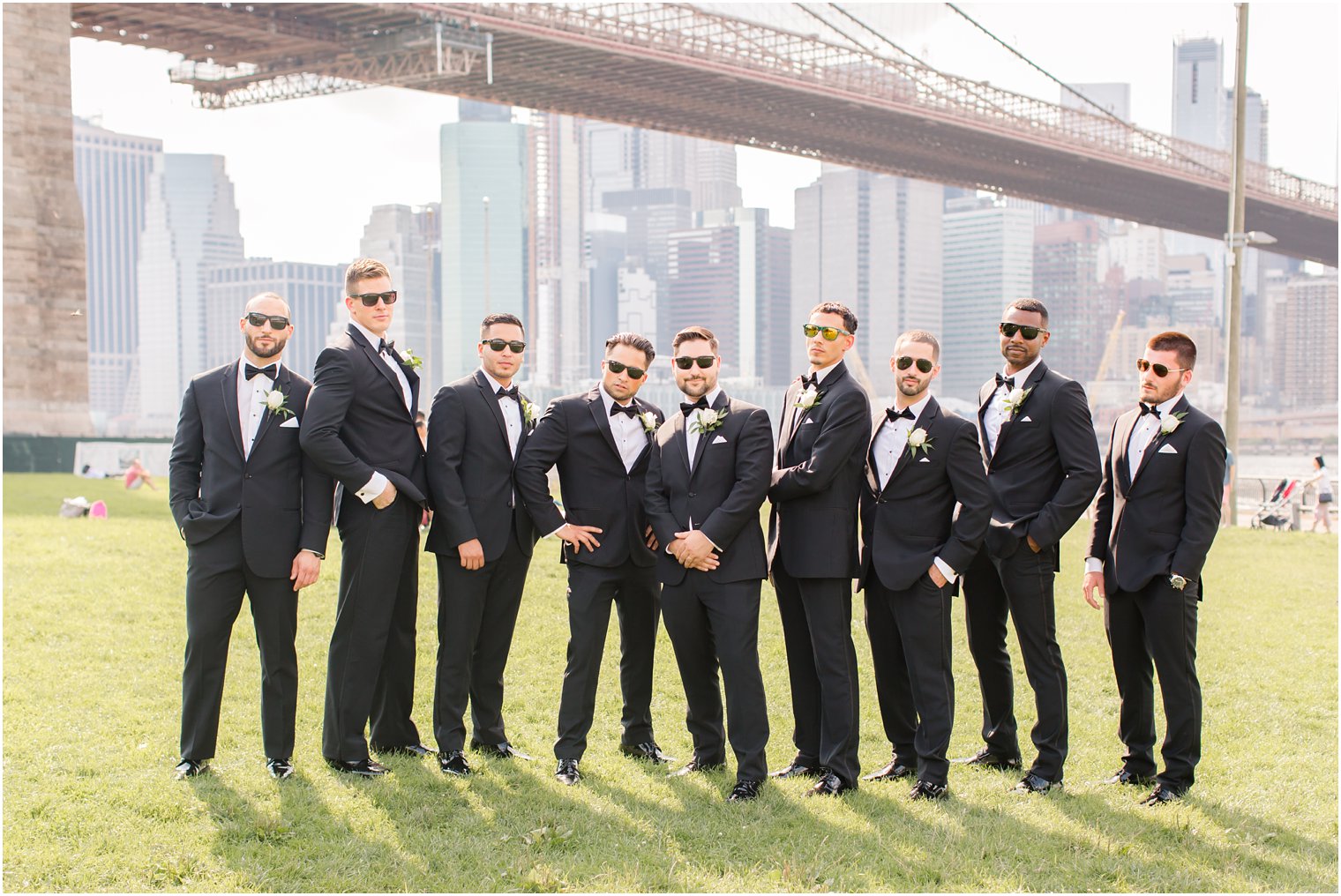 Groomsmen posing for photos in front of Brooklyn Bridge