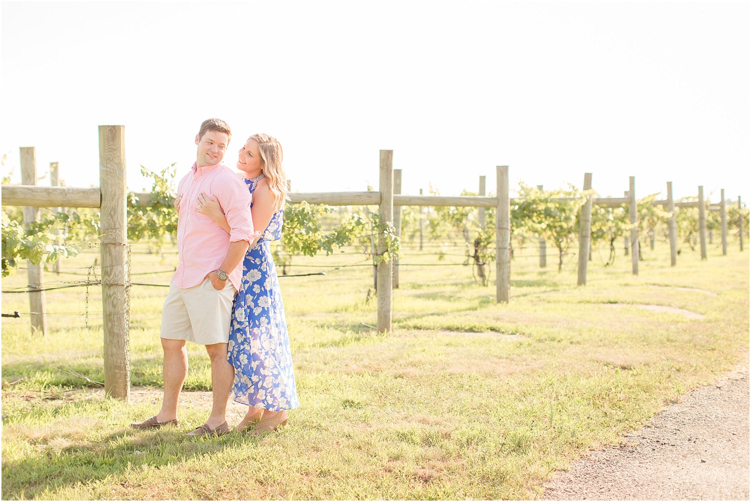 Couple stands with vines at Laurita Winery during engagement session