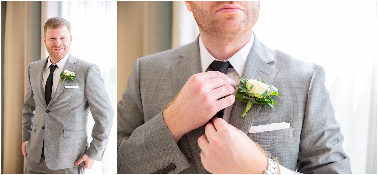 Groom adjusts black tie in grey suite from Calvin Klein at Ocean Place Resort and Spa