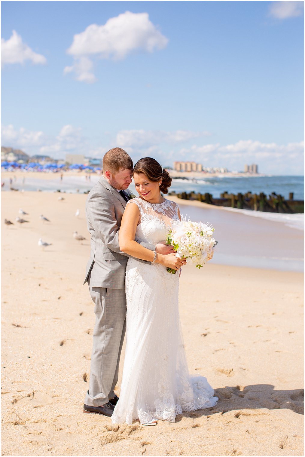 groom in Calvin Klein suit embraces bride in Maggie Sottero dress at Ocean Place Resort and Spa