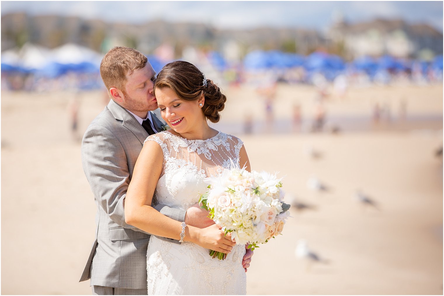 groom gives bride a kiss on the beach in Long Branch NJ 