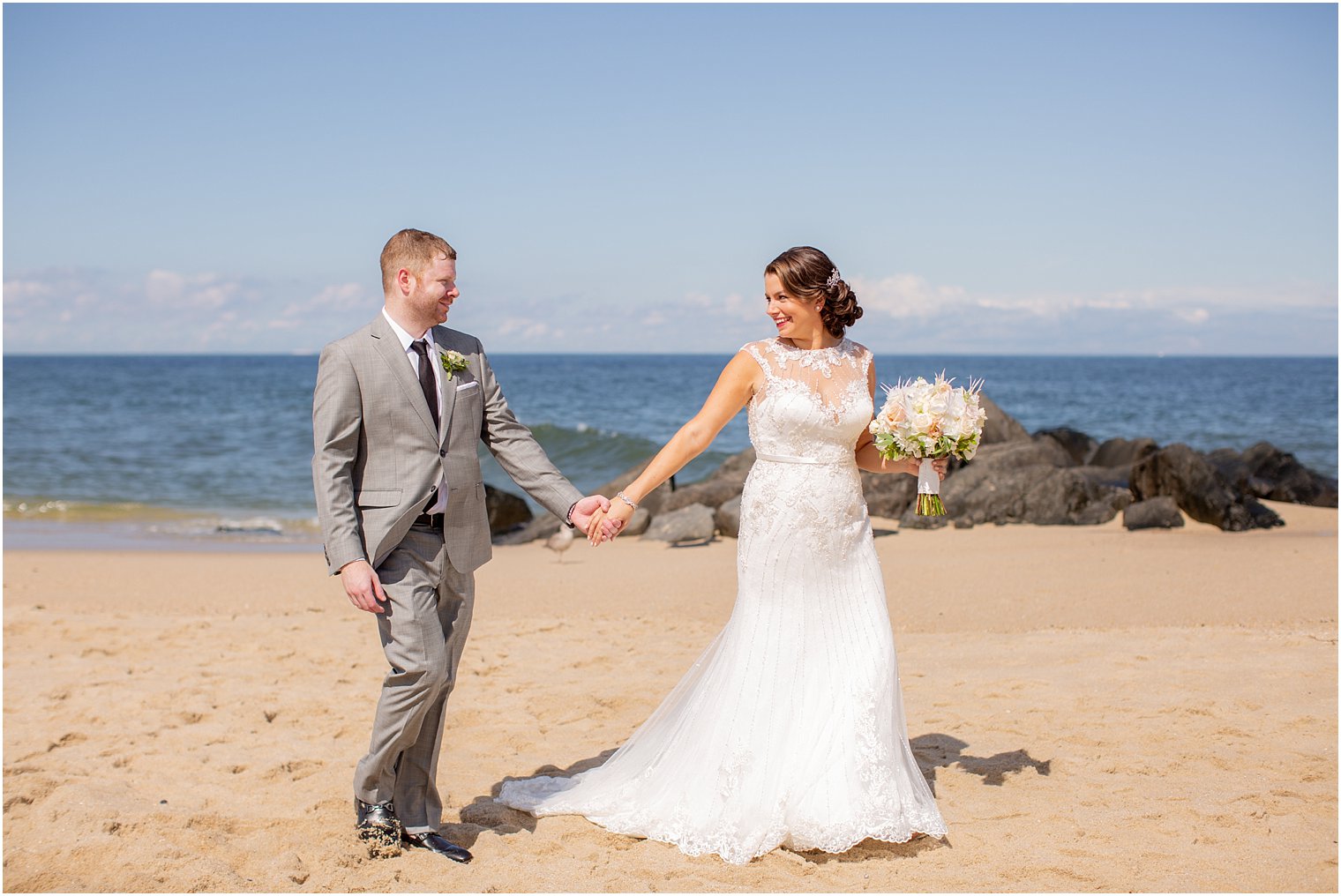 bride and groom walking along beach at Ocean Place Resort and Spa