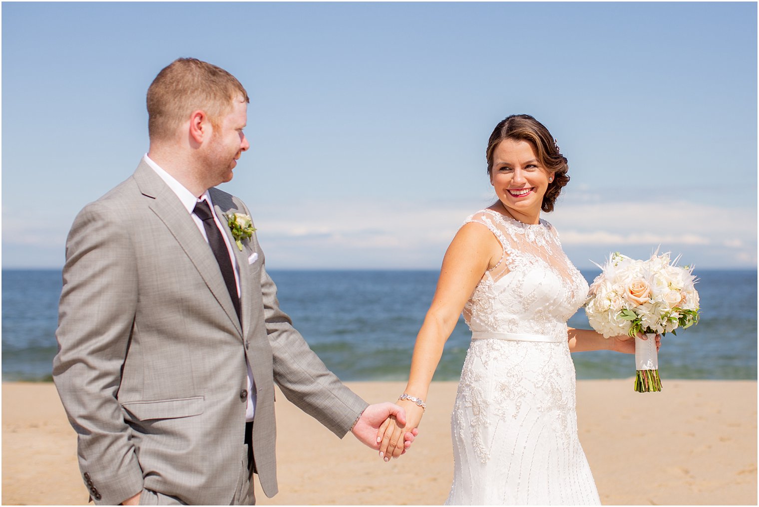 bride smiles at groom on beach at Ocean Place Resort and Spa