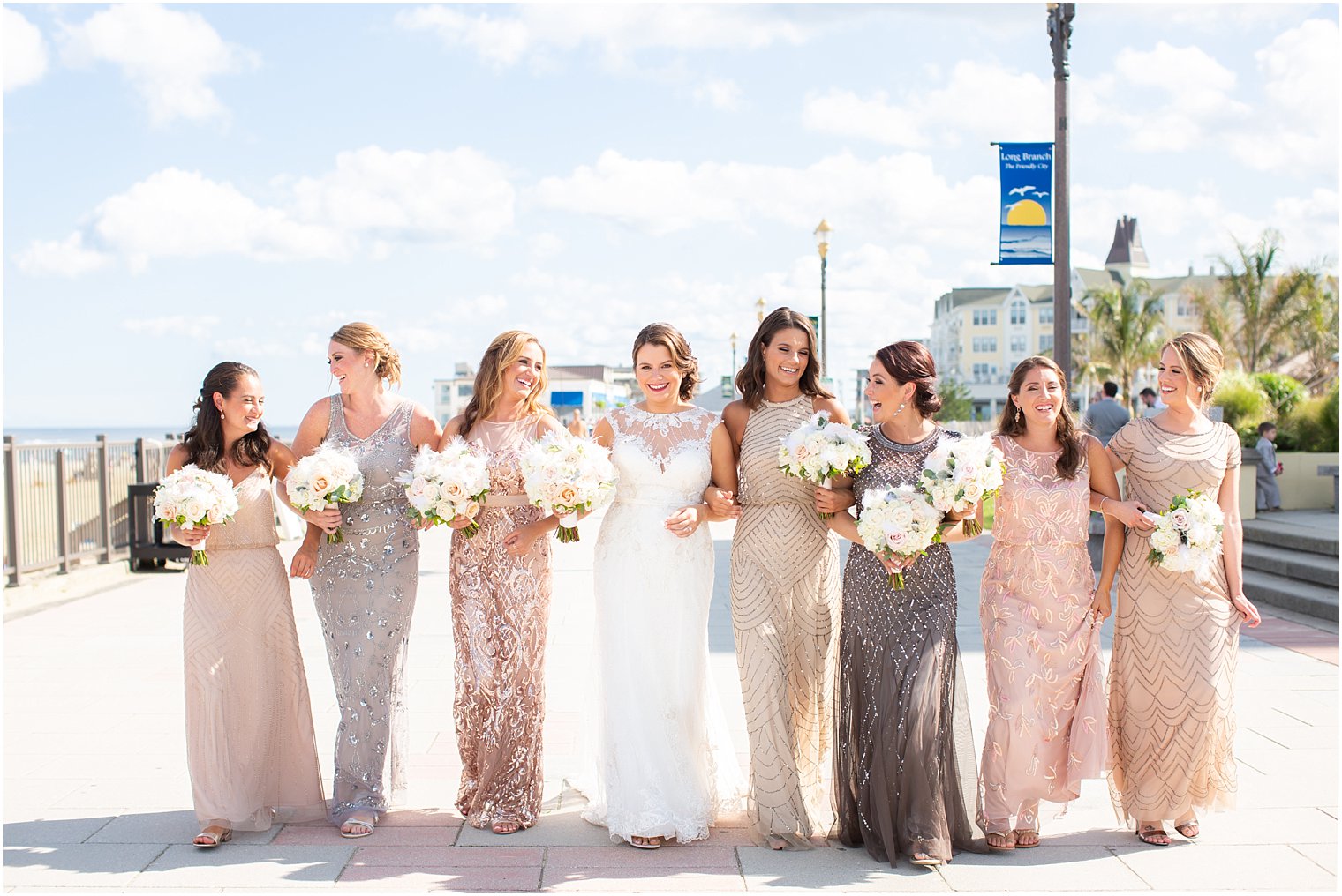 bridesmaids and bride walking down boardwalk in Long Branch, NJ photographed by Idalia Photography