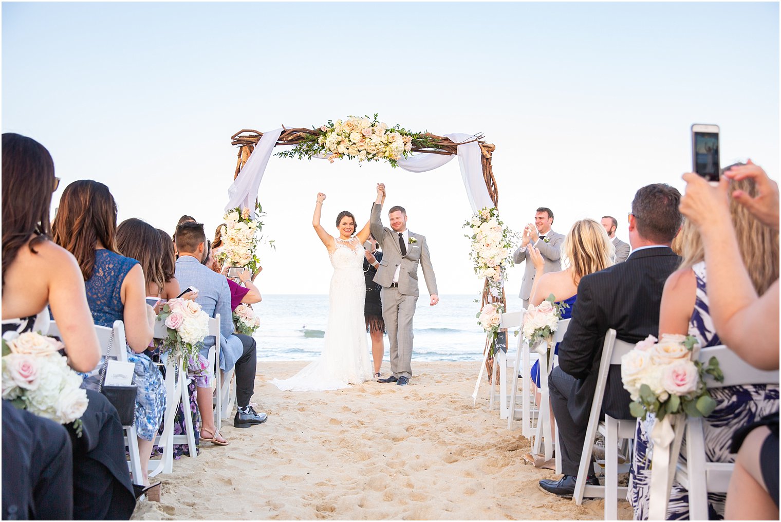bride and groom celebrate wedding at beachfront wedding ceremony photographed by Idalia Photography