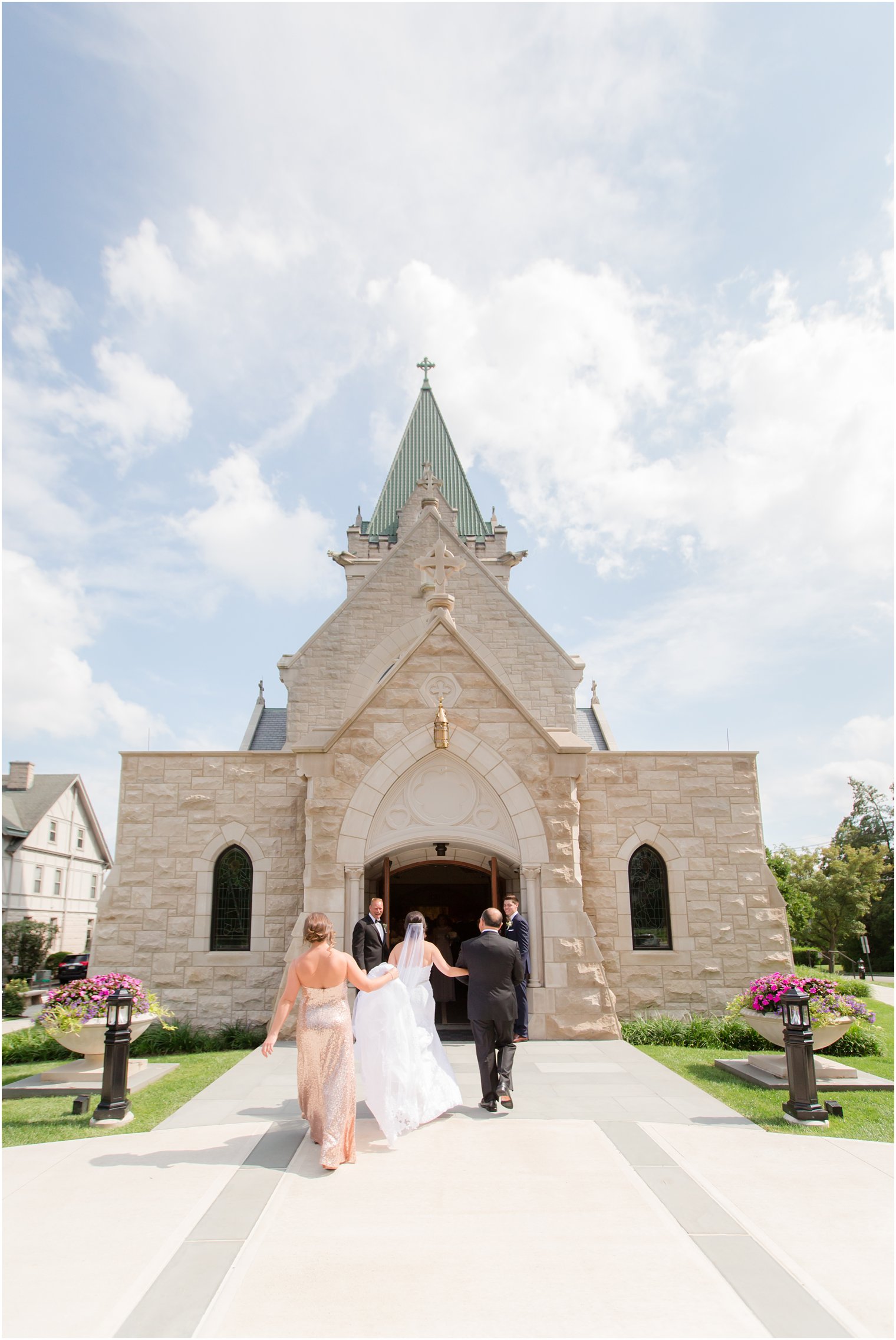 bride enters NJ church on wedding day with father and bridesmaid photographed by Idalia Photography