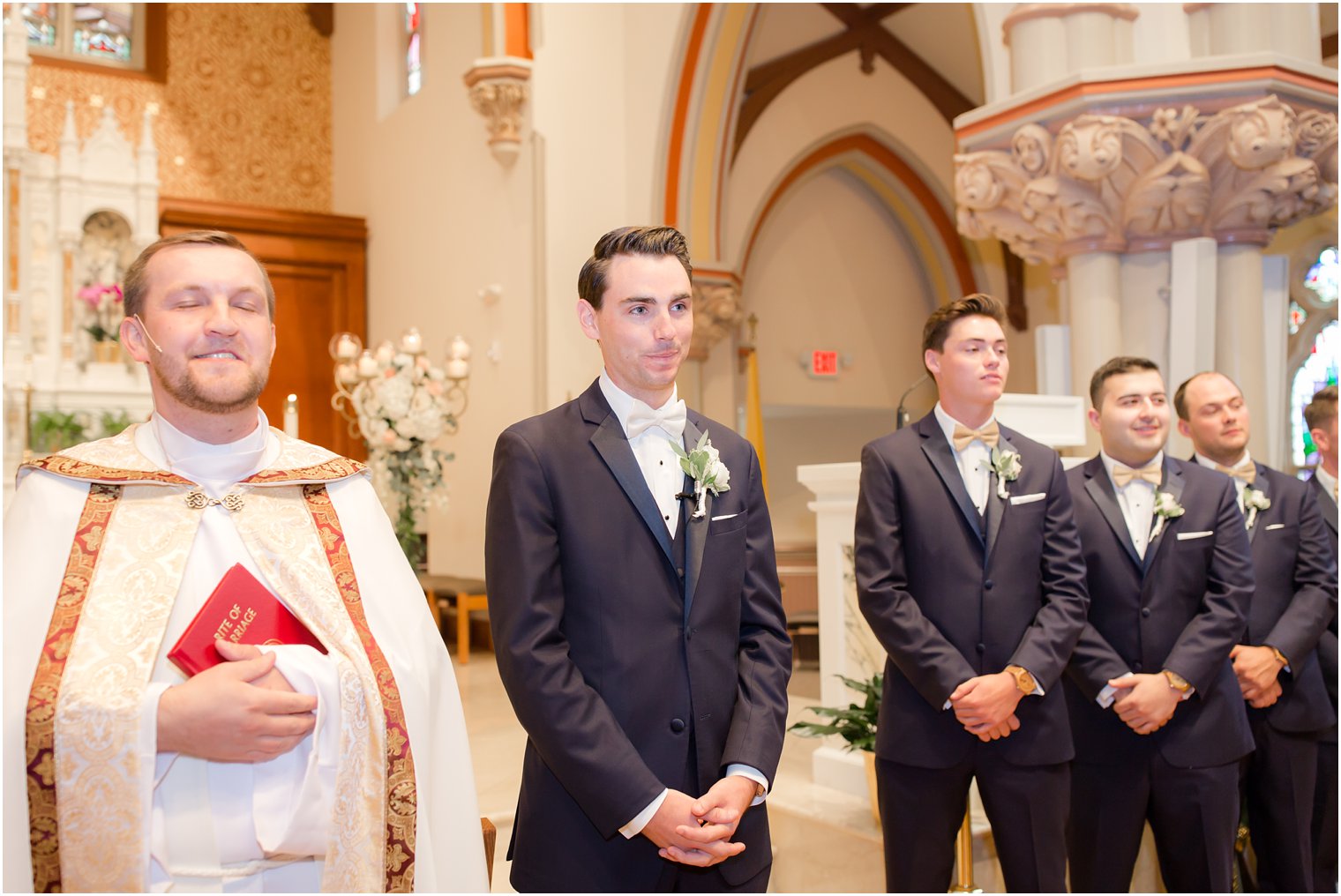 groom waits for bride to come down aisle at NJ church ceremony photographed by Idalia Photography
