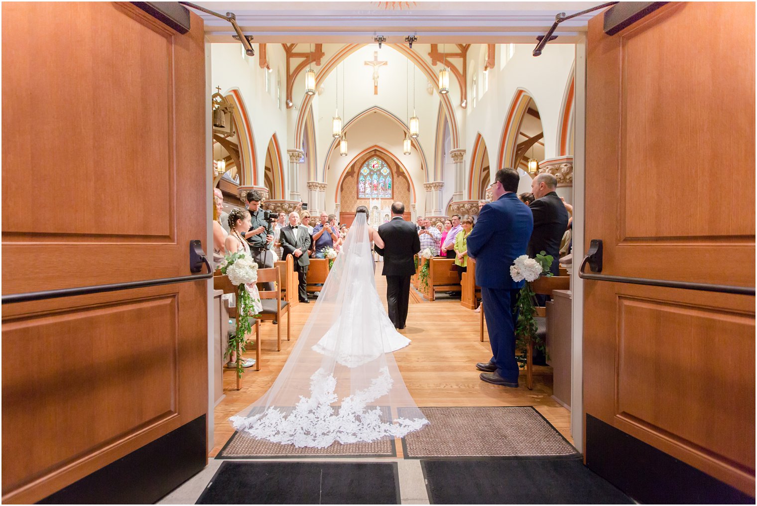 bride wearing Pnina Tornai wedding gown enters NJ church for wedding ceremony photographed by Idalia Photography