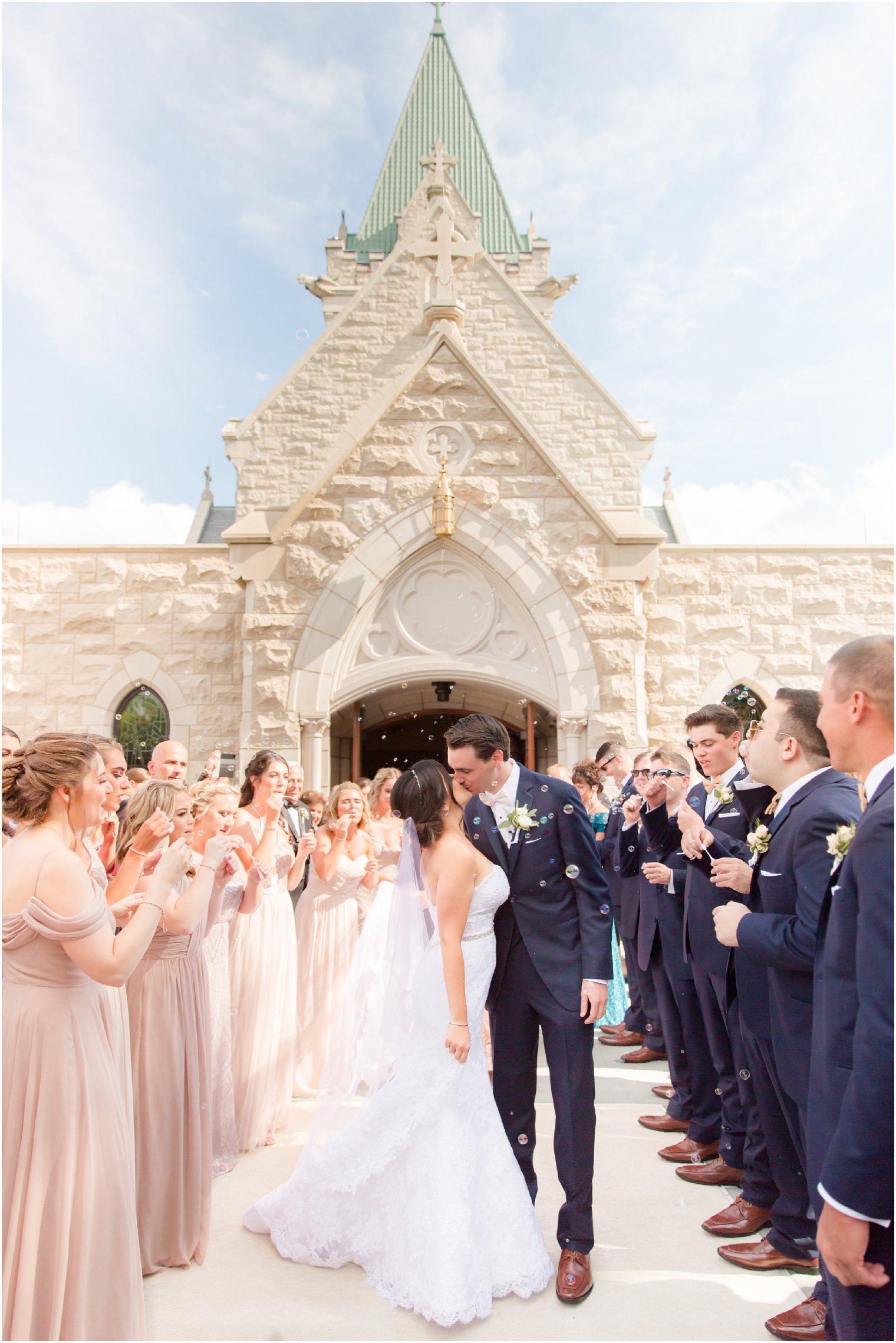 bride and groom kiss during bubble exit outside NJ church photographed by Idalia Photography