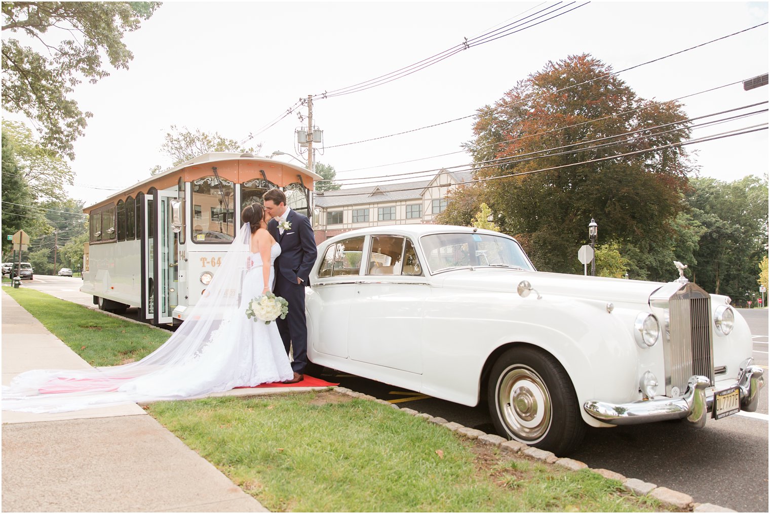 bride and groom kiss by Rolls Royce outside wedding ceremony photographed by Idalia Photography