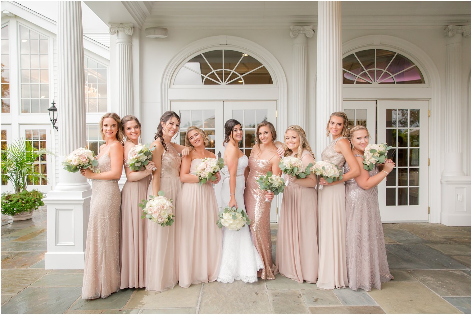 bride poses with bridesmaids in rose gold bridesmaid dresses at Park Savoy Estate 