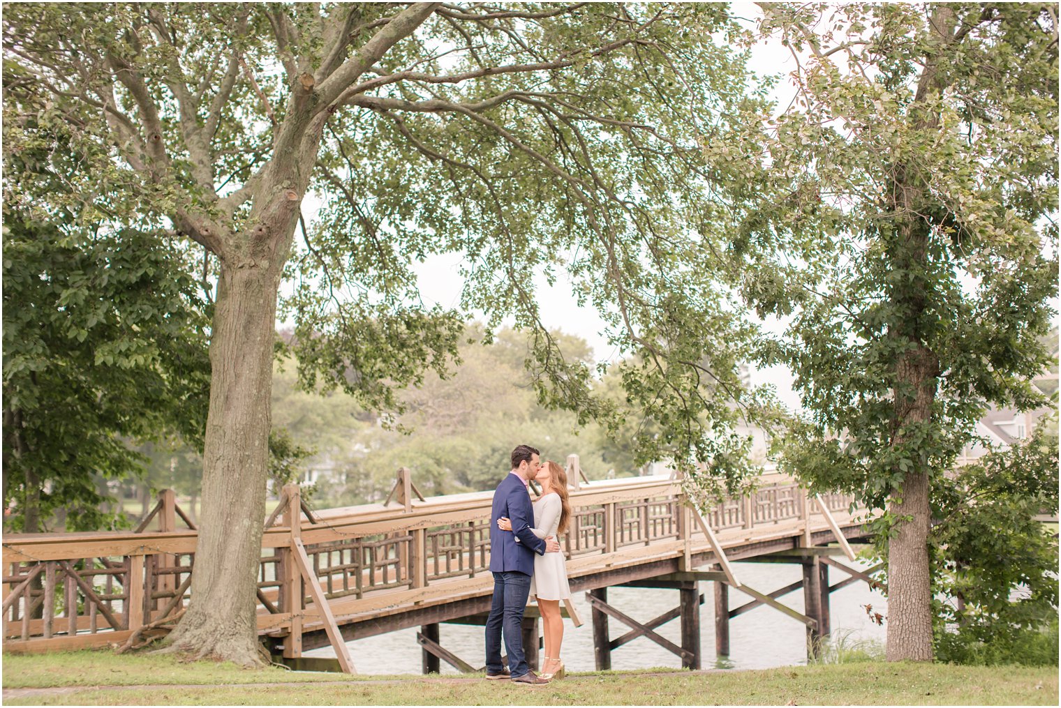couple kisses by bridge during Spring Lake NJ engagement session