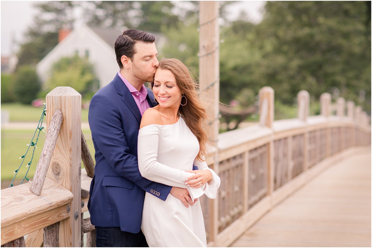 groom gives bride to be a kiss on the forehead during engagement session at spring lake NJ 