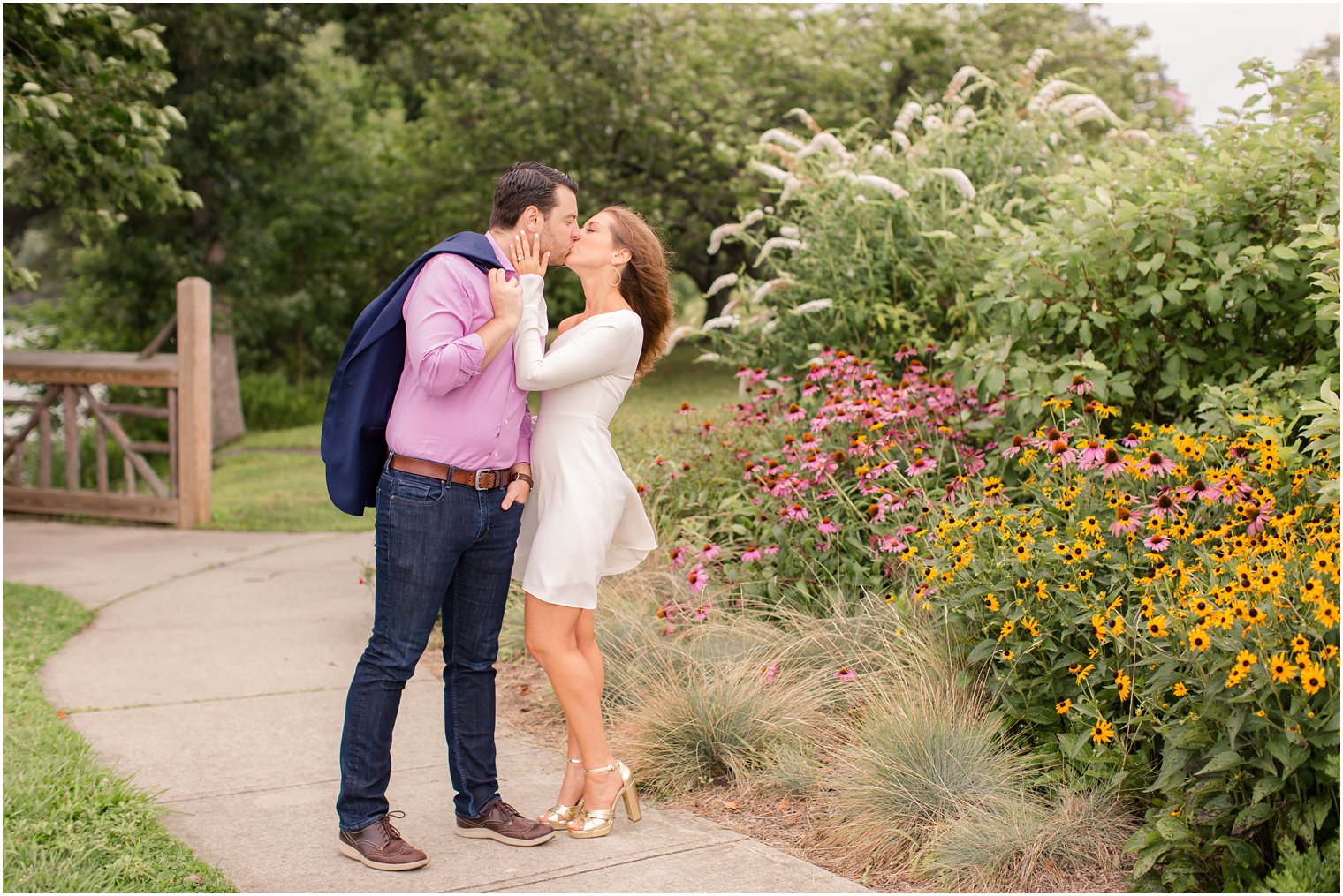 kiss by the flowers in the summer photographed by Idalia Photography during Spring Lake NJ engagement session