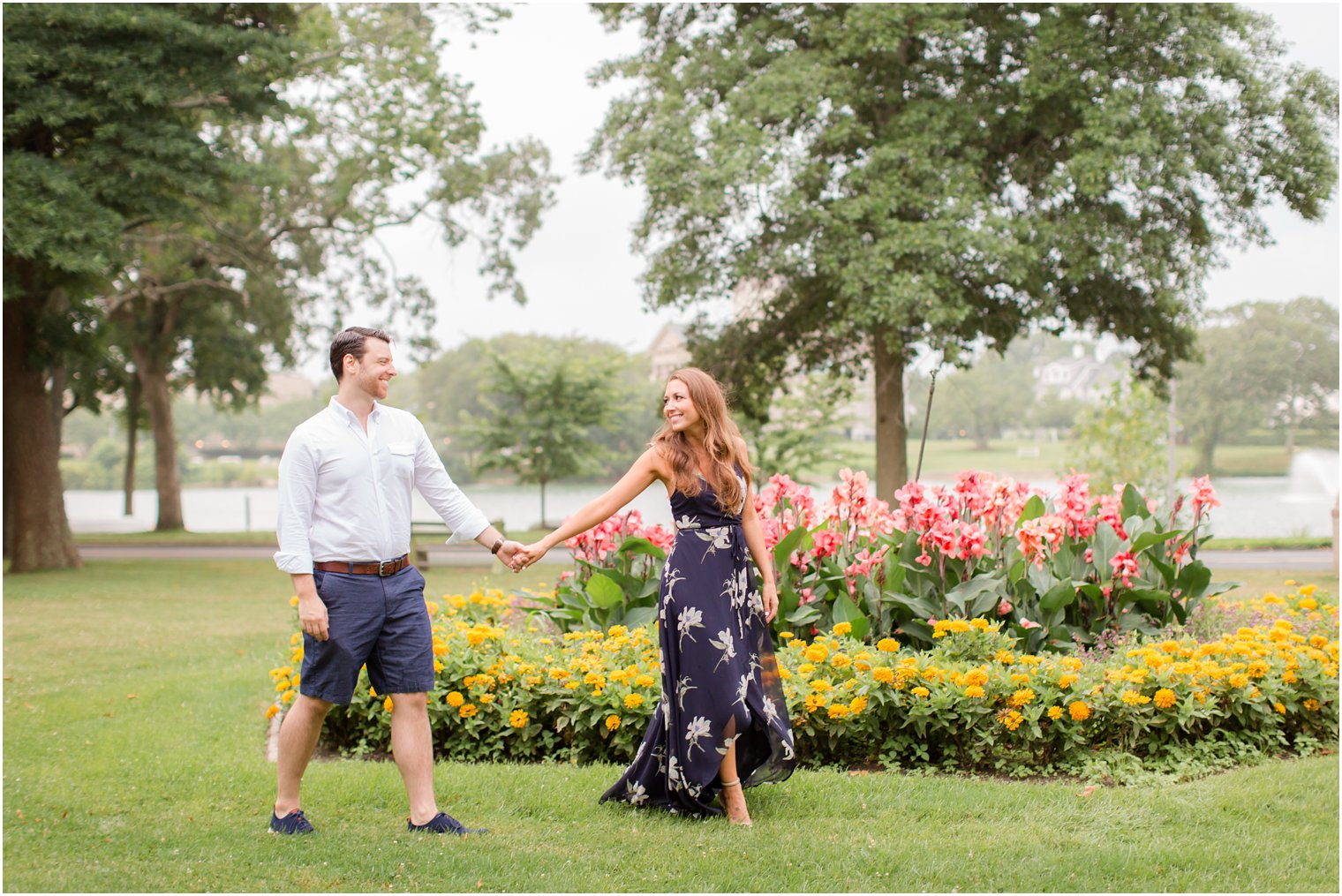 bride and groom hold hands and walk by garden during Spring Lake NJ Engagement session