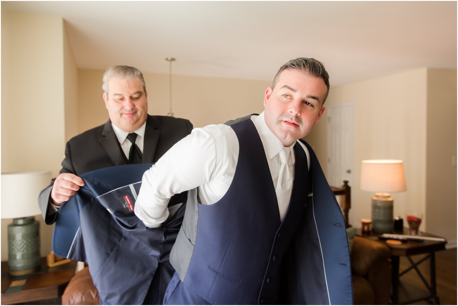 groom puts on jacket before Palace at Somerset Park wedding day photographed by Idalia Photography