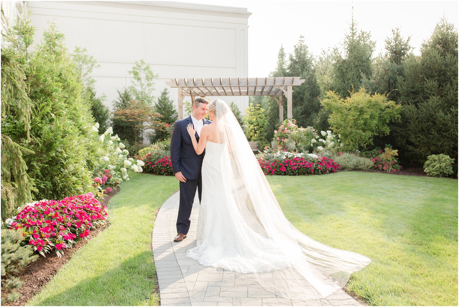 bride and groom pose by arbor at the Palace at Somerset Park