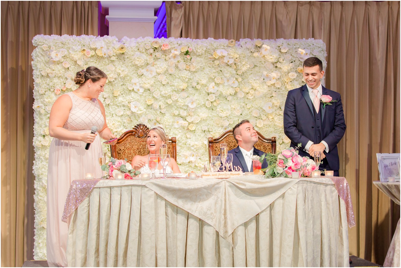 bride and groom at sweetheart table with floral wall at the Palace at Somerset Park