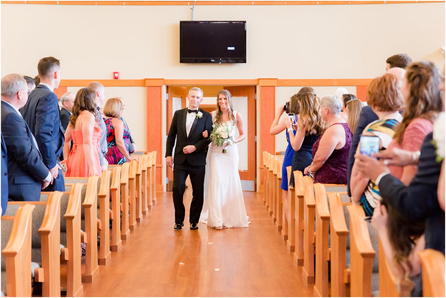 bride walks down the aisle with her father at Princeton Meadow Church in NJ