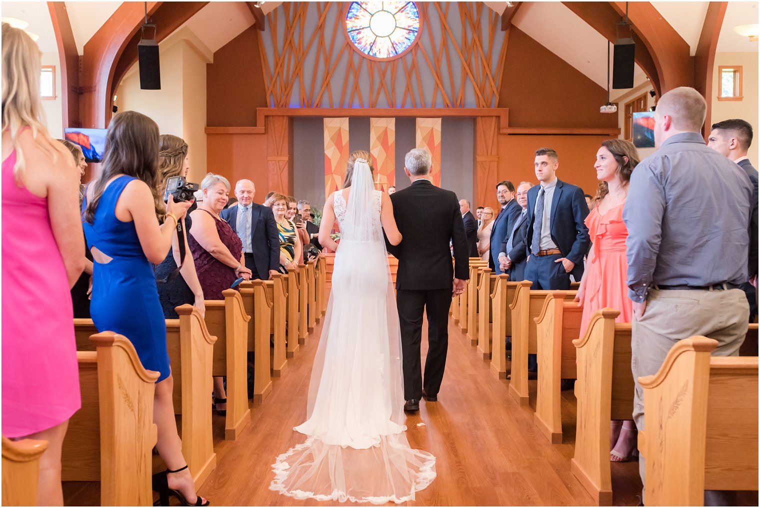 bride walks down aisle in Daalarna Couture wedding gown at Princeton Meadow Church