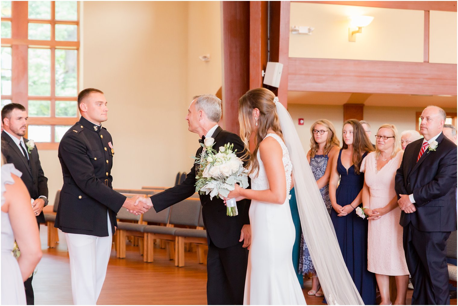 groom shakes father of the bride's hand during wedding ceremony at Princeton Meadow Church