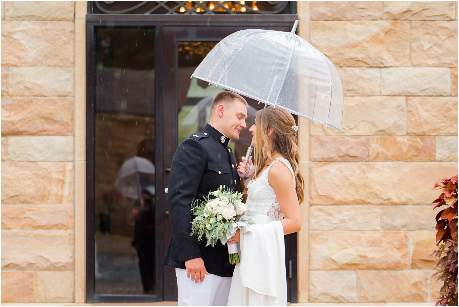 Bride and groom pose under umbrella on rainy wedding day at Jasna Polana