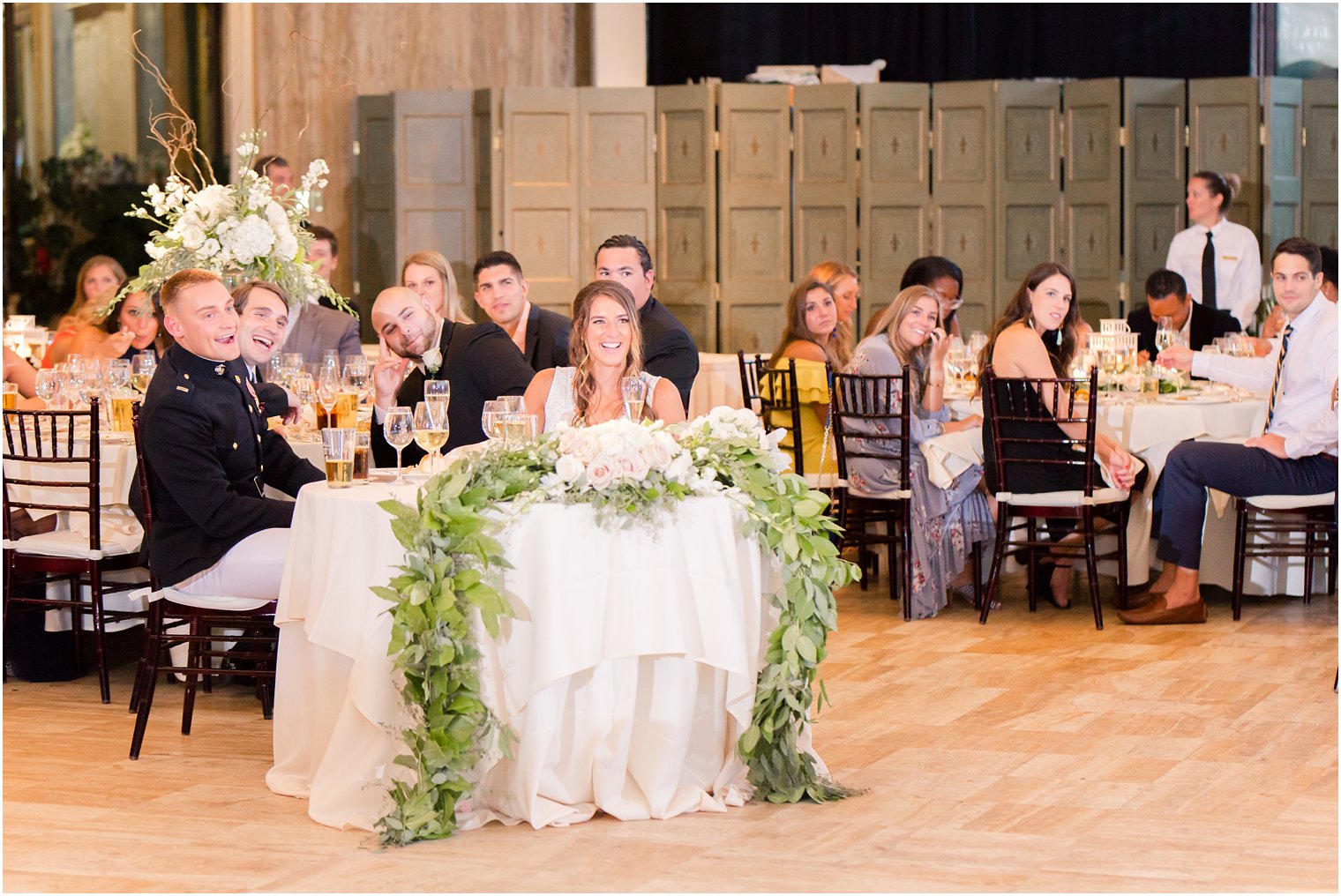 bride and groom laughing during reception at Jasna Polana with florals on sweetheart table by Meghan Pinsky