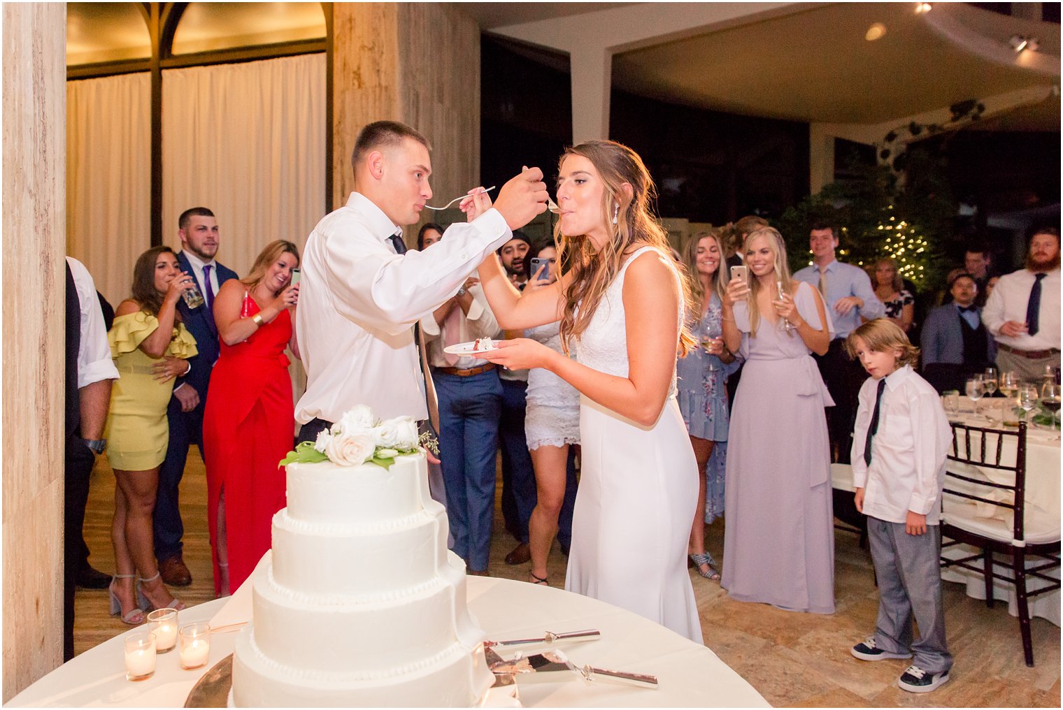 bride and groom eat cake at Jasna Polana during wedding reception