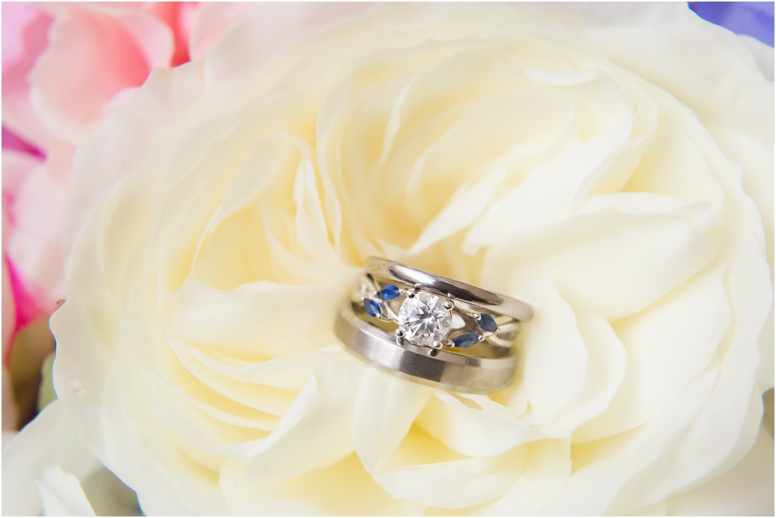 Silver and diamond wedding bands on ivory florals by Secret Garden photographed by NJ wedding photographer Idalia Photography