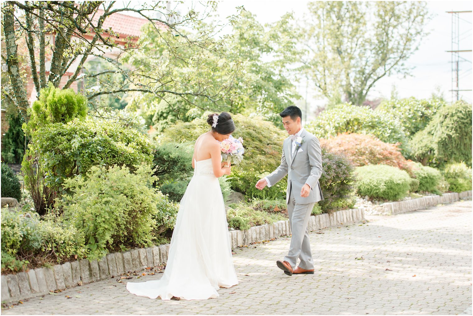 Groom looks at bride's wedding dress at The Bethwood in New Jersey photographed by Idalia Photography