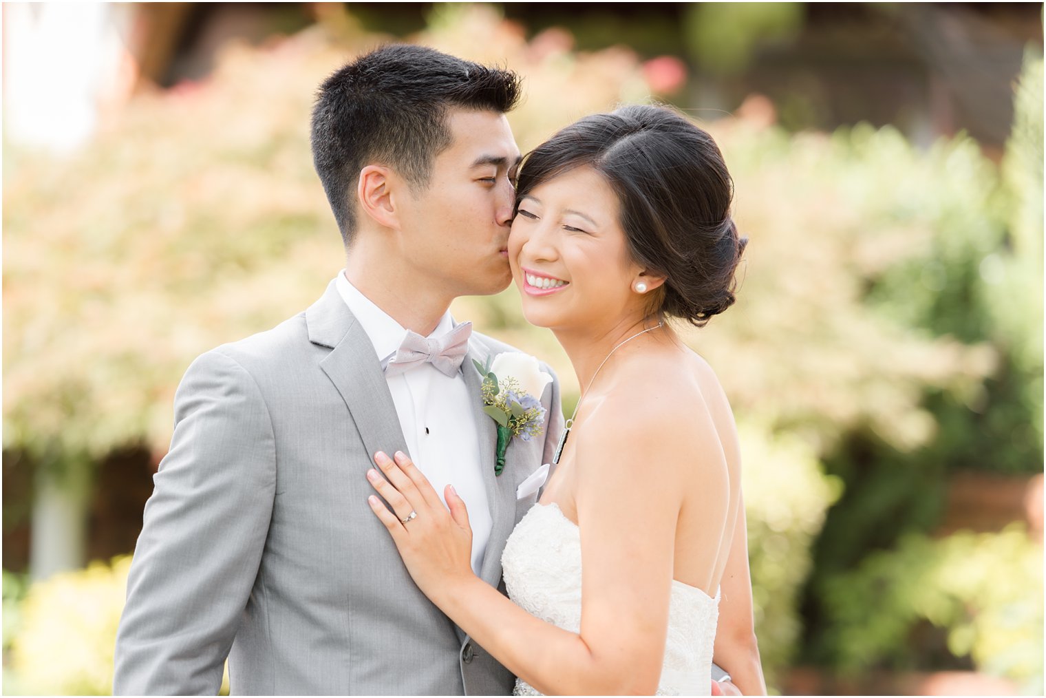 Groom gives bride a kiss during portraits with Idalia Photography in New Jersey