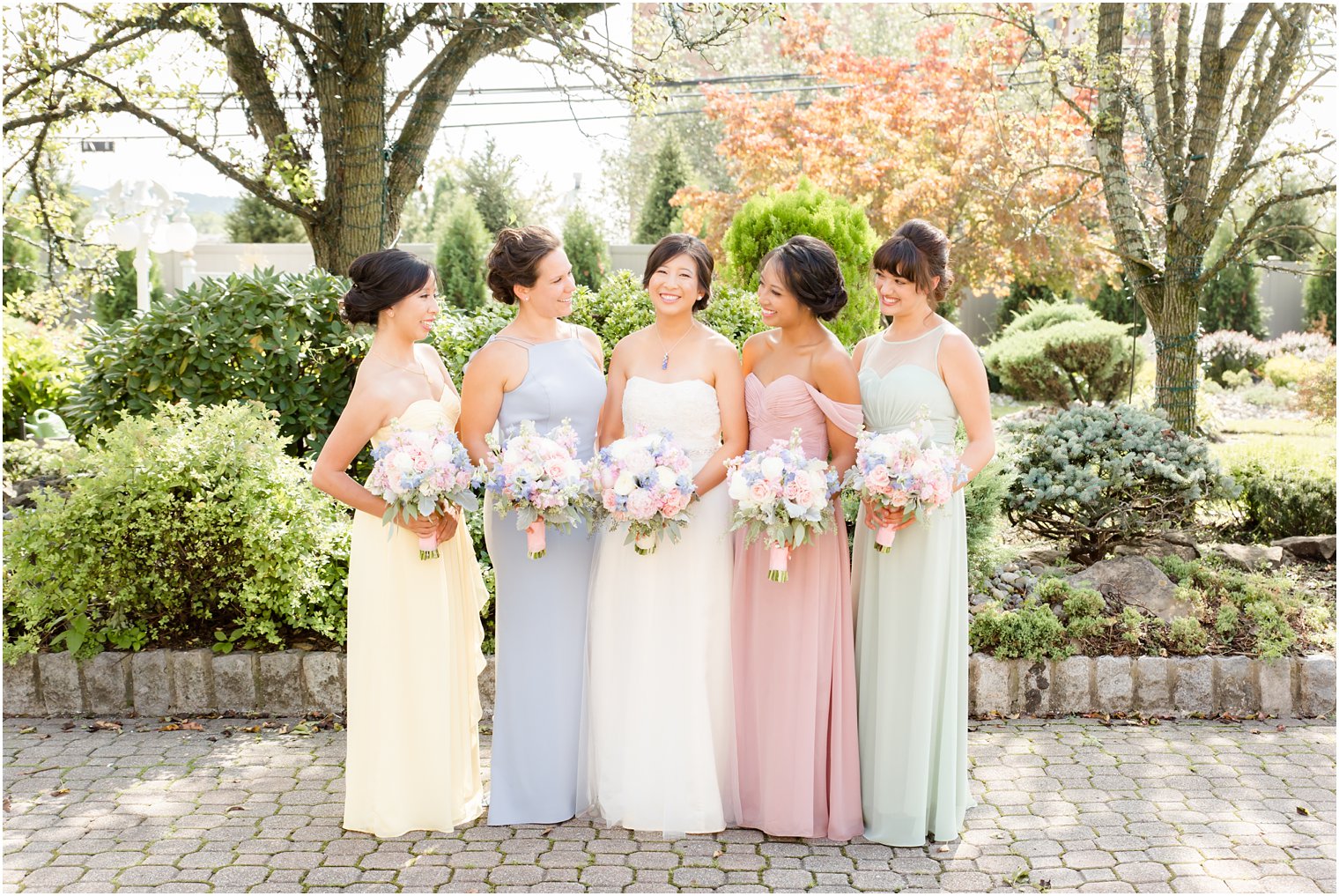 bridesmaids look at bride with pink and purple bouquets from Secret Garden