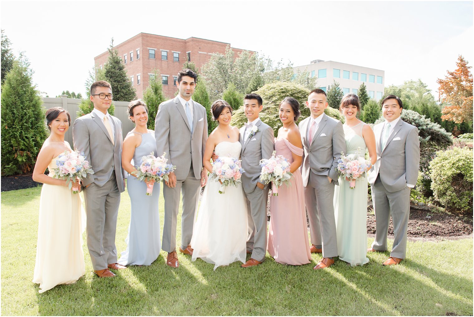 Summer wedding party with light grey suits and pastel gowns at The Bethwood