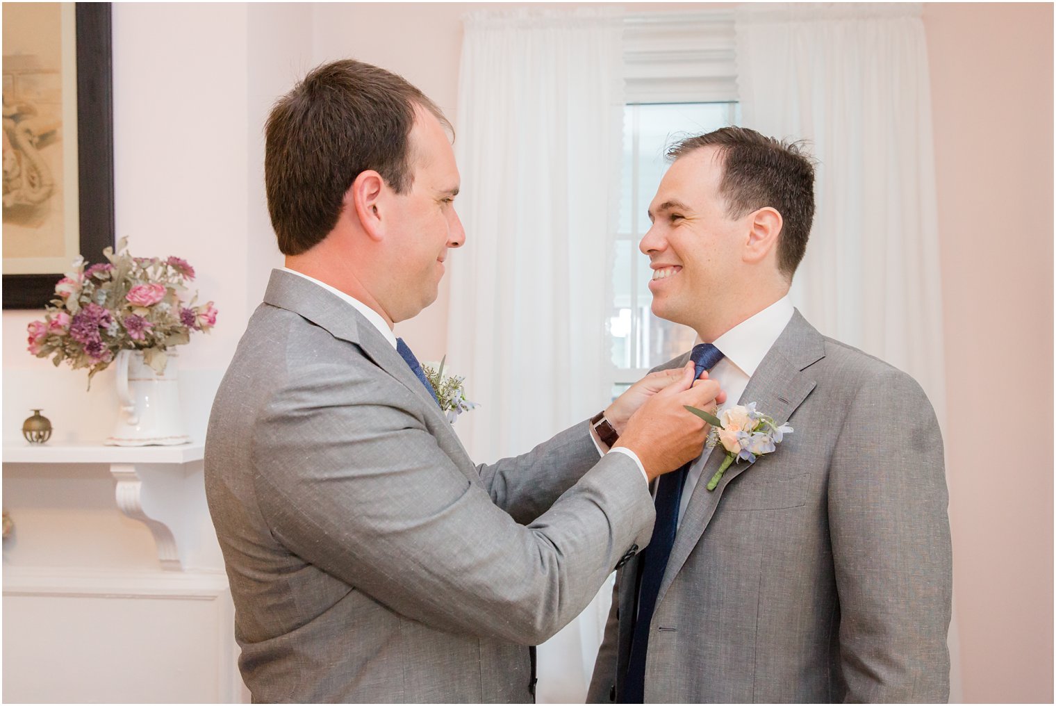 groomsmen helps groom with tie before Brant Beach Yacht Club wedding day