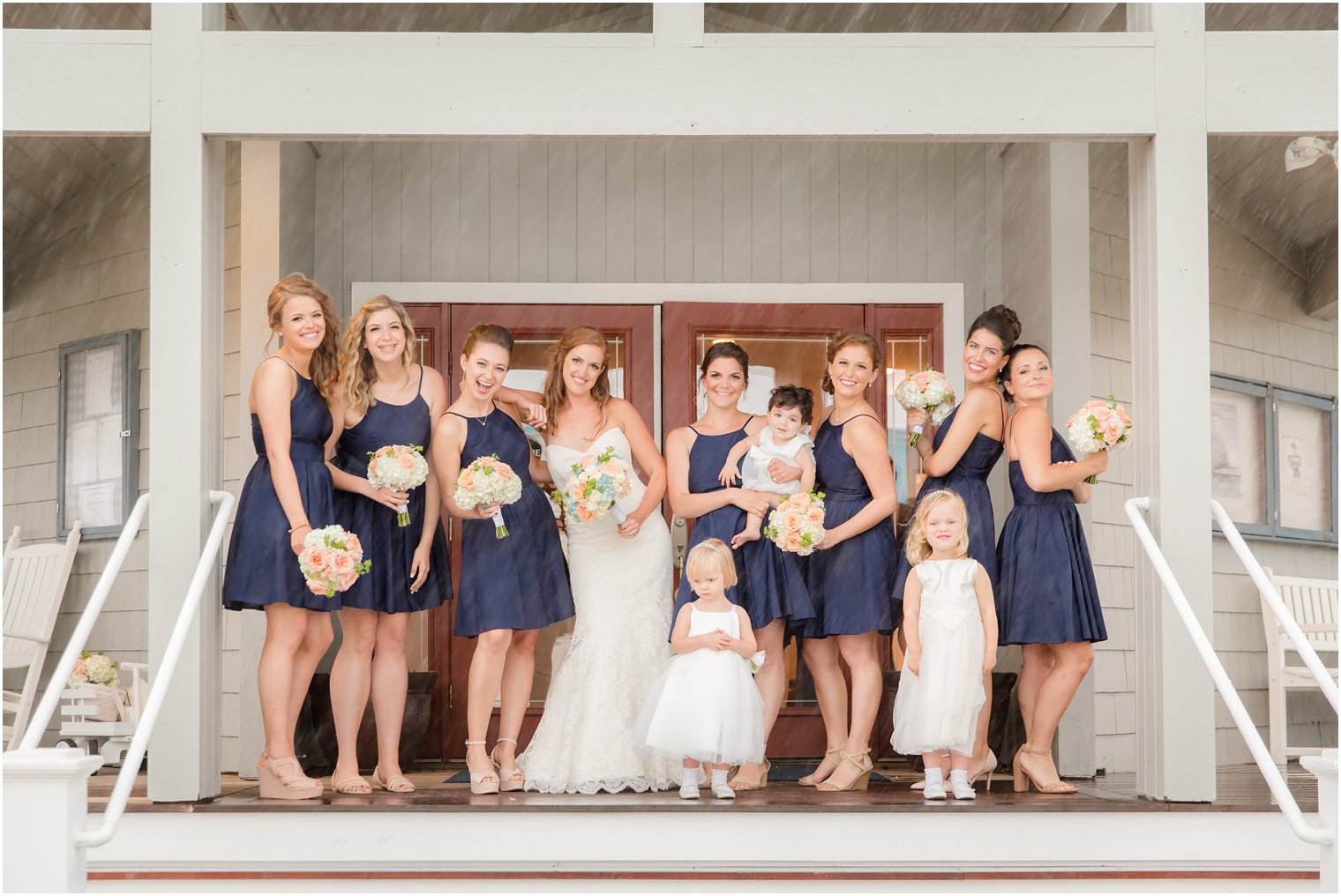 bride with bridesmaids in navy gowns photographed by Idalia Photography