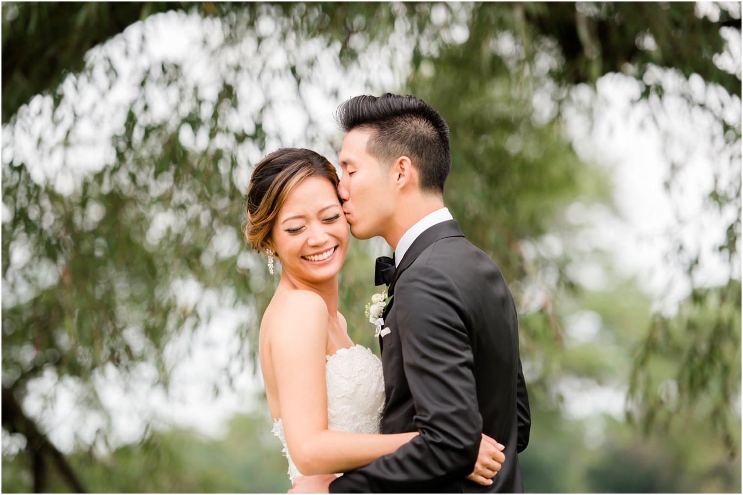 groom gives bride a kiss on wedding day photographed by Idalia Photography