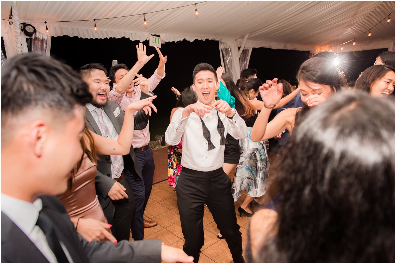 groom dances during outdoor tented reception at Chauncey Hotel photographed by Idalia Photography