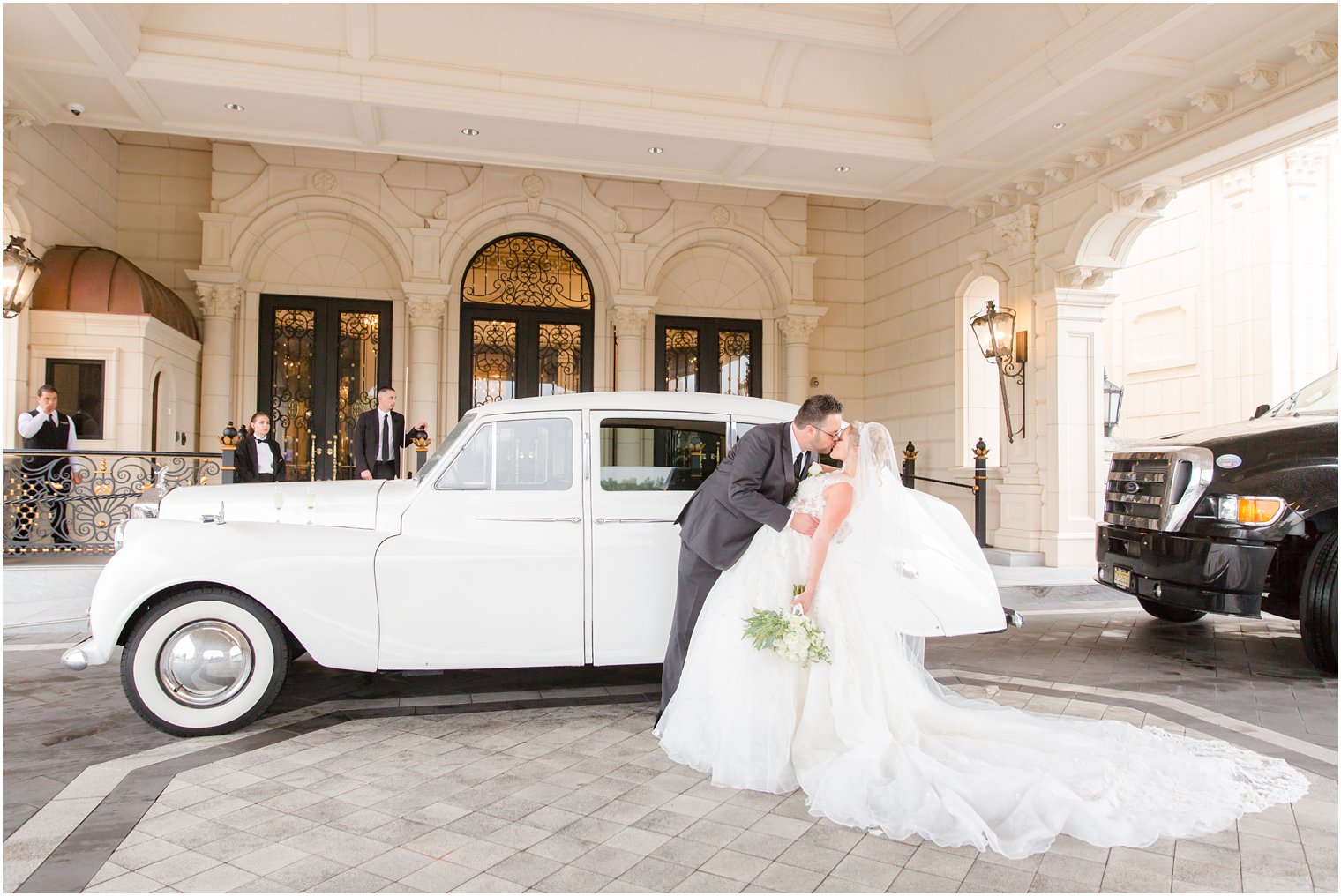 bride and groom pose by classic car at Legacy Castle photographed by Idalia Photography